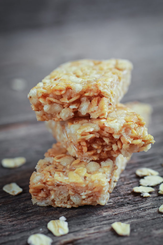 Three pieces of granola barre with fresh oat on a wooden table