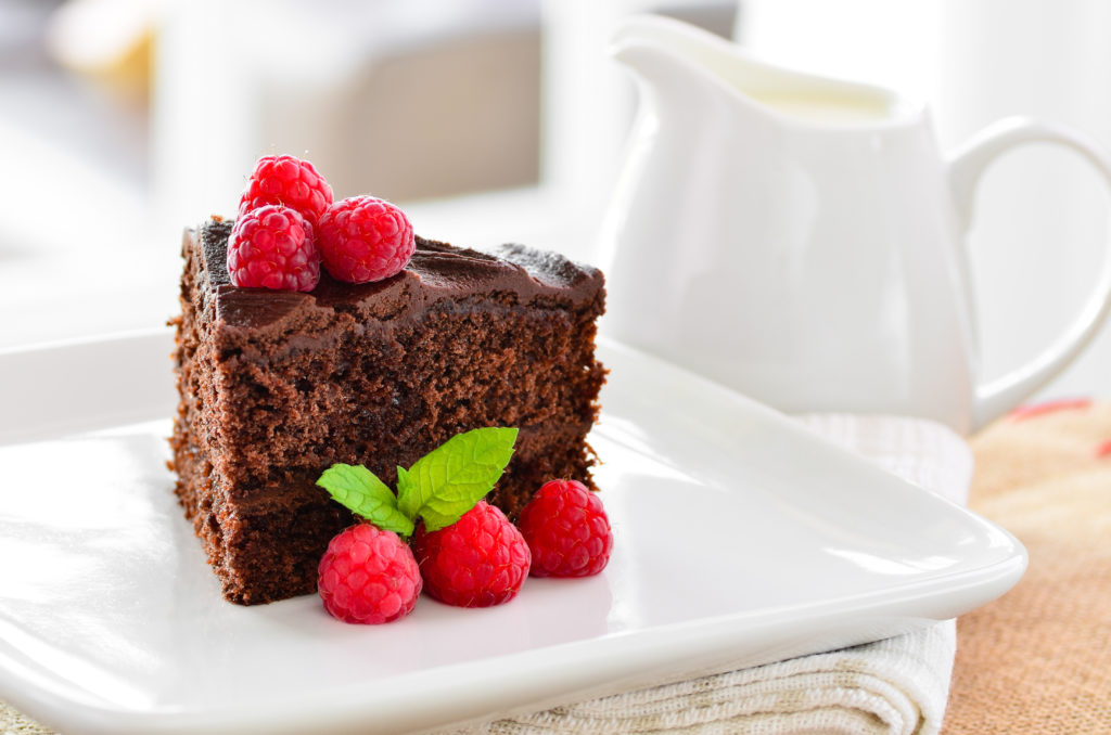 Fresh home made sticky chocolate fudge cake with raspberries